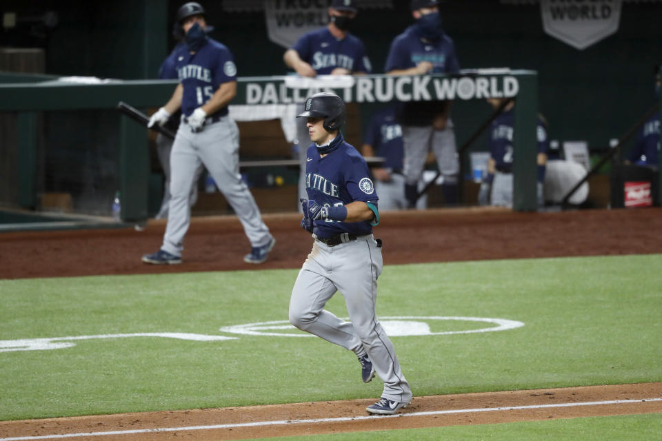 Seattle Mariners shortstop Dylan Moore runs home past the dugout after hitting a solo home run against the Texas Rangers in the seventh inning of a baseball game in Arlington, Texas, Monday, Aug. 10, 2020. (AP Photo/Tony Gutierrez)