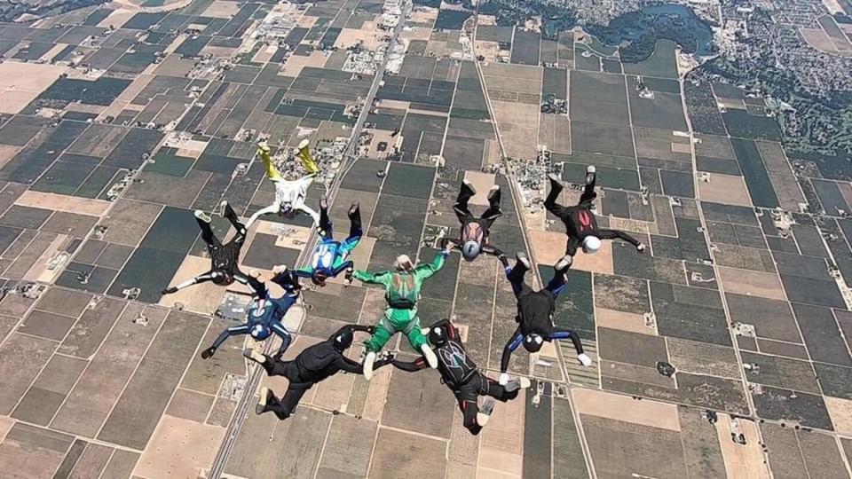 Sabrina Call, in the teal and green suit, links arms with her husband, Mark “Shoobie” Knutson, in green, during a group skydive. Call was an avid skydiver with more than 2,100 jumps to her name.