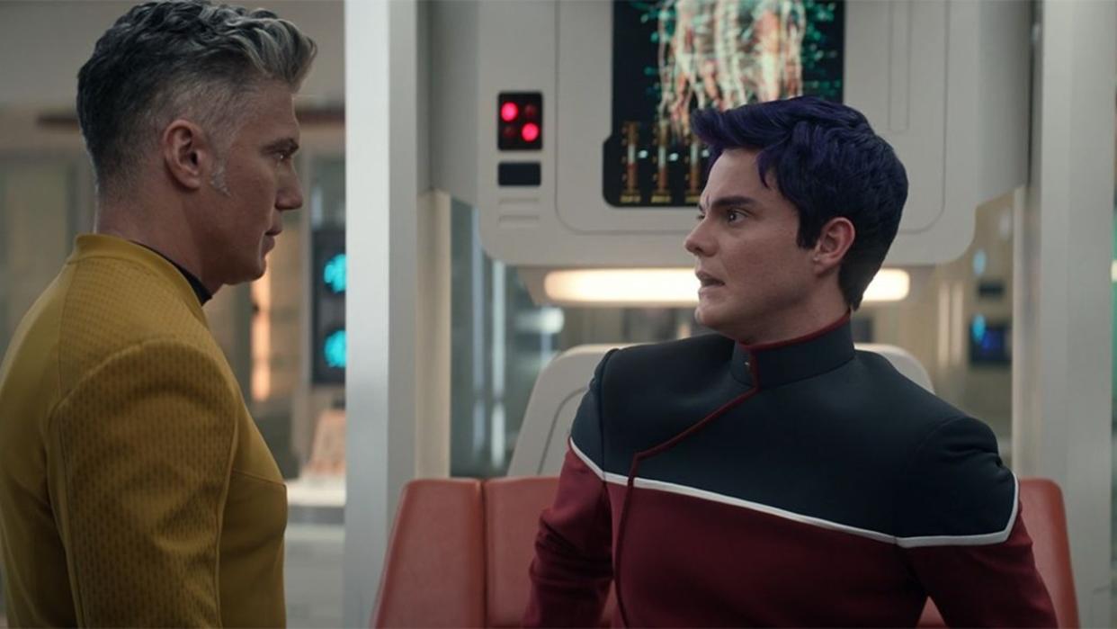  two men in starfleet uniforms look at one another 