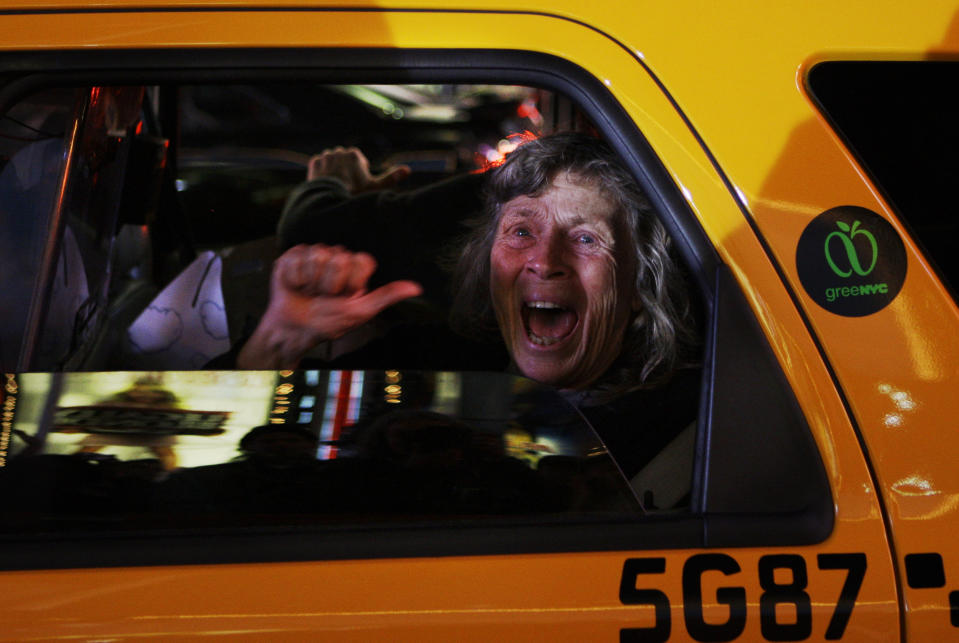 FILE - A woman reacts while sitting in a taxi as different television networks call the presidential race for Barack Obama, in New York on Tuesday, Nov. 4, 2008. (AP Photo/Anja Niedringhaus, File)