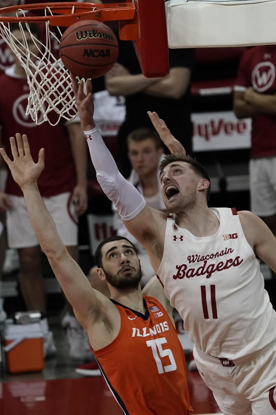 Wisconsin's Micah Potter shoots past Illinois's Giorgi Bezhanishvili during the second half of an NCAA college basketball game Saturday, Feb. 27, 2021, in Madison, Wis. (AP Photo/Morry Gash)