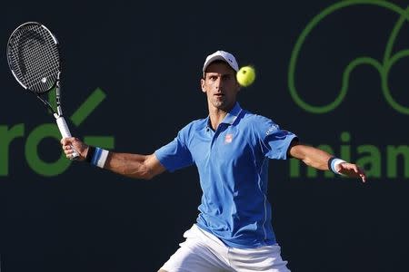 Mar 31, 2015; Key Biscayne, FL, USA; Novak Djokovic hits a forehand against Alexandr Dolgopolov (not pictured) on day nine of the Miami Open at Crandon Park Tennis Center. Djokovic won 6-7 (3), 7-5, 6-0. Mandatory Credit: Geoff Burke-USA TODAY