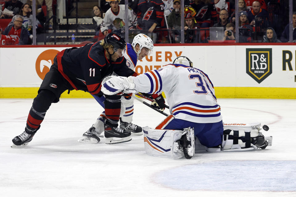 Carolina Hurricanes' Jordan Staal (11) loses control of the puck between Edmonton Oilers' Ryan Nugent-Hopkins (93) and goaltender Calvin Pickard (30) during the second period of an NHL hockey game in Raleigh, N.C., Wednesday, Nov. 22, 2023. (AP Photo/Karl B DeBlaker)