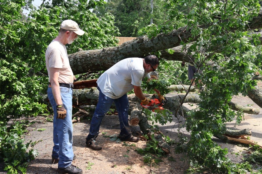 Charlie Little, 72, Chris Block, 47 and Gunner Block, 20, help clear a street in Centerton.