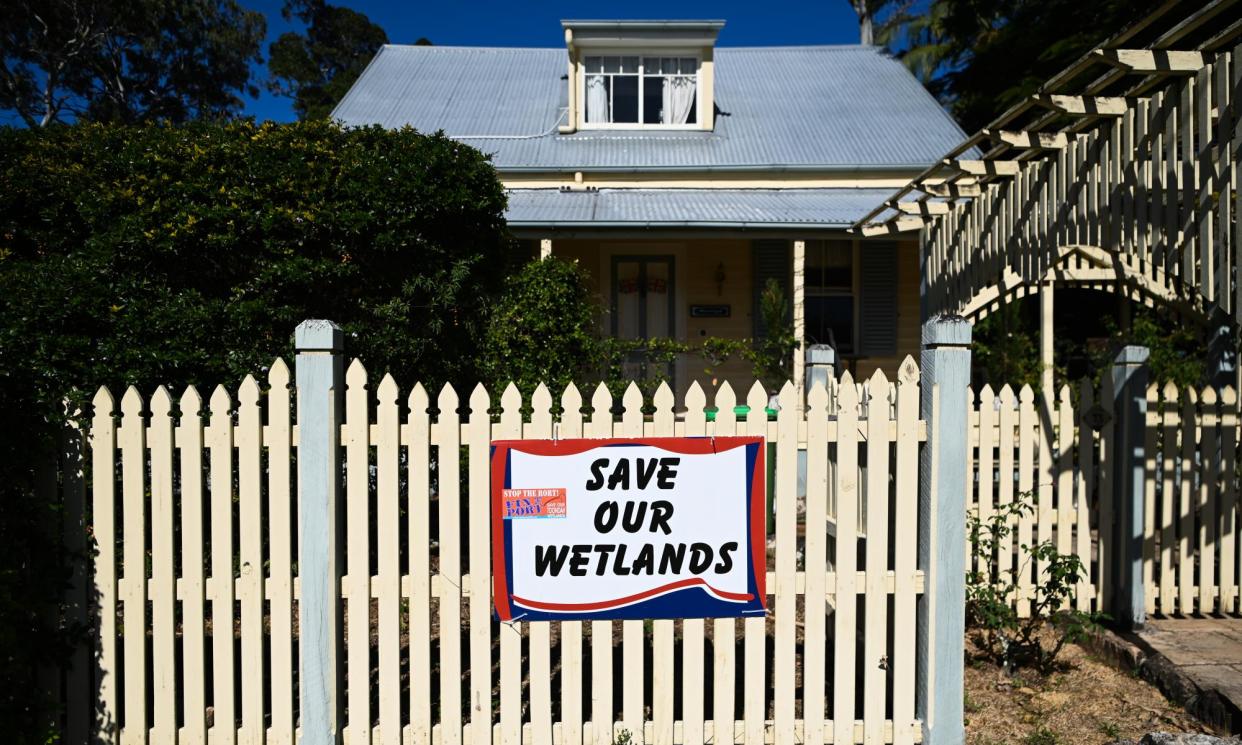 <span>A sign on a fence in Cleveland, near Toondah harbour, opposing the development.</span><span>Photograph: Dan Peled/The Guardian</span>