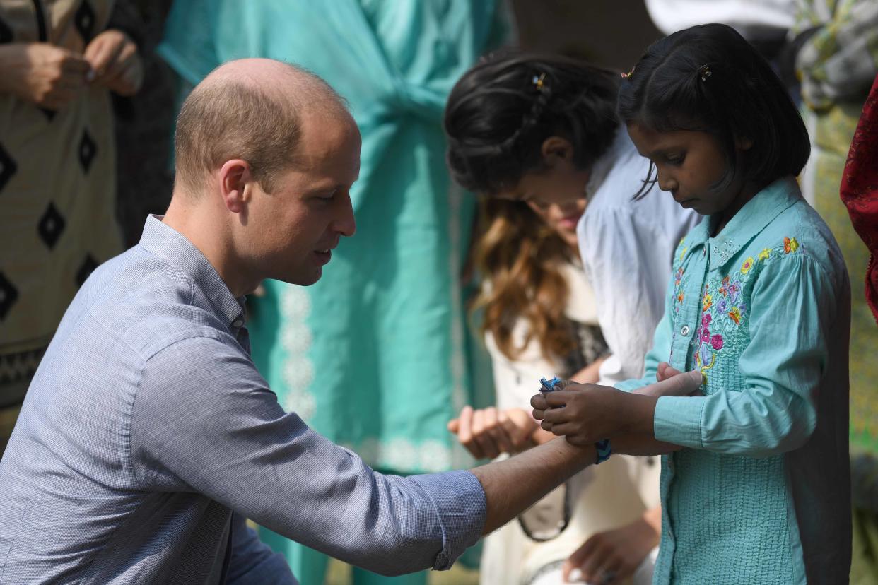 LAHORE, PAKISTAN - OCTOBER 18: Prince William, Duke of Cambridge receives a bracelet on a visit to the SOS Village on October 18, 2019 in Lahore, Pakistan. (Photo by Neil Hall - Pool/Getty Images)