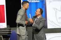 Atlanta Hawks general manager Landry Fields, left, shakes hands with NBA Deputy Commissioner Mark Tatum after Tatum announced that the Hawks had won the first pick in the NBA draft, during the draft lottery in Chicago, Sunday, May 12, 2024. (AP Photo/Nam Y. Huh)