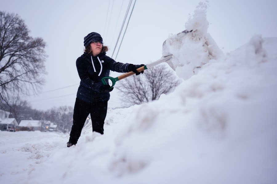 Graphic designer Emily Brewer shovels out her driveway in order to drive to work in Sioux City, Iowa, early on Friday, Jan. 12, 2024. (AP Photo/Carolyn Kaster)