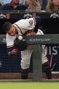 Atlanta Braves' Ehire Adrianza (23) leans over the dugout railing to catch a foul ball in his hat during a baseball game against the Philadelphia Phillies Tuesday, Sept. 28, 2021, in Atlanta. (AP Photo/John Bazemore)