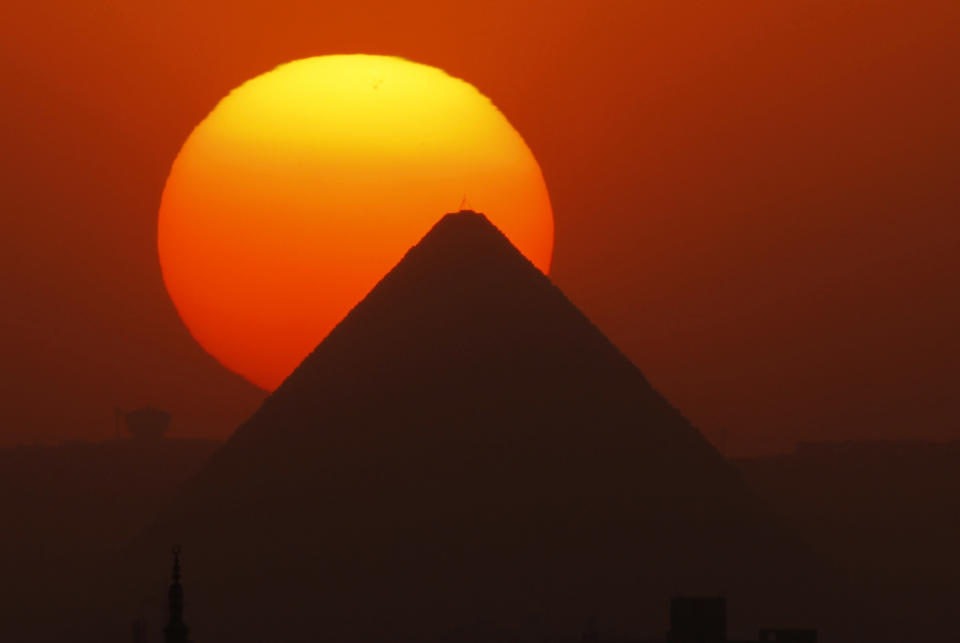 The sun sets behind the Great Pyramid in Giza, Egypt, Friday, April 26, 2013. Elsewhere, dozens of mostly masked protesters are hurling stones and firebombs in clashes with riot police at Egypt’s presidential palace in a Cairo suburb. Protests have become a weekly routine in Egypt, as the country has plunged in turmoil during most of the past two years since 2011 uprising which ousted longtime president Hosni Mubarak out of power. (AP Photo/Amr Nabil)