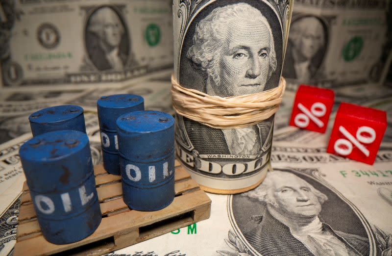 FILE PHOTO: 3D printed oil barrels and percentage symbols are seen in front of dollar banknotes in this illustration