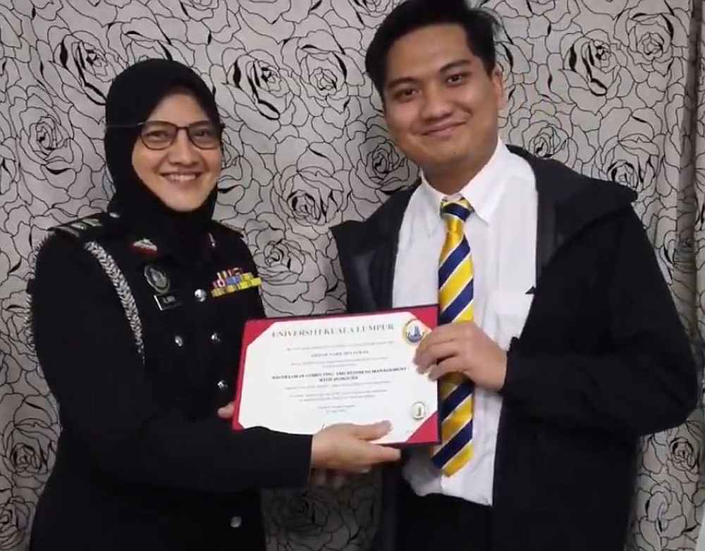 Ahmad Nabil (right) receiving his graduation certificate from his mother in his creative home convocation ceremony. — Twitter/AhmadNabil