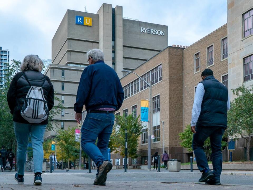 Students, along with other pedestrians, walk through Ryerson University's campus in downtown Toronto under light drizzle on Monday, Oct. 18, 2021.  (Sam Nar/CBC - image credit)