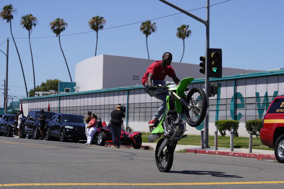 Riders perform motorcycle tricks before the start of the third annual Juneteenth Drive-Thru Parade at Inglewood High School in Inglewood. Calif., Sunday, June 19, 2022. (AP Photo/Damian Dovarganes)