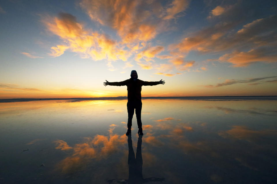 A visitor to Bonneville Salt Flats poses for a photograph pm Sunday, Oct. 9, 2022, near Wendover, Utah. (AP Photo/Rick Bowmer)