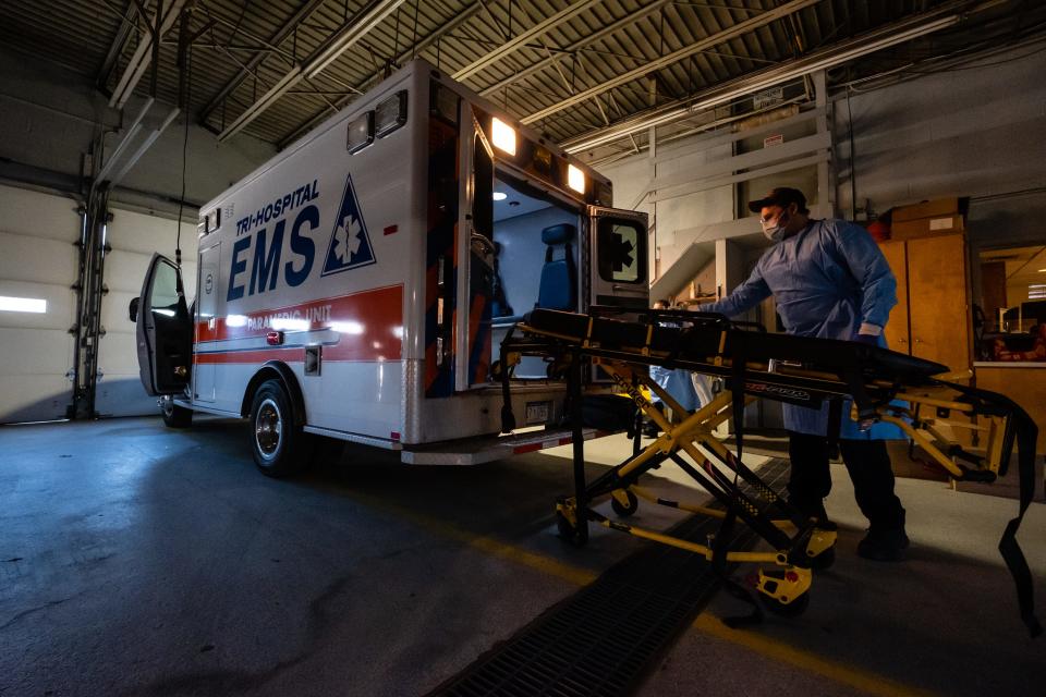 Tri-Hospital EMS Paramedic Jason Burdeaux disinfects a stretcher behind an ambulance Friday, April 3, 2020, in the Tri-Hospital EMS garage in Port Huron.