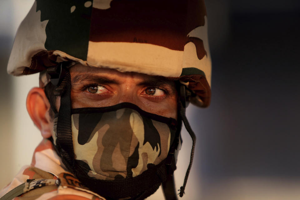 An Indian para-military force soldier stands guard at an intersection in Jammu, India, July 24, 2020. Most of the para-military soldiers have not gone home or taken leave since August last year after New Delhi scraped Kashmir's semi-autonomous status and divided the Himalayan territory into two federally governed regions. Indian-controlled Kashmir has remained on edge after New Delhi last summer scrapped the disputed region’s semi-autonomy amid a near-total clampdown. While deeply unpopular in Muslim-majority Kashmir, the sudden move resonated in India, where Prime Minister Narendra Modi was cheered by supporters for fulfilling a long-held Hindu nationalist pledge. (AP Photo/Channi Anand)