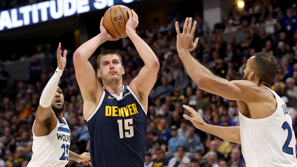 Nikola Jokic #15 of the Denver Nuggets goes to the basket against Monte Morris #23 and Rudy Gobert #27 of the Minnesota Timberwolves during the first quarter at Ball Arena on April 10, 2024 in Denver, Colorado.