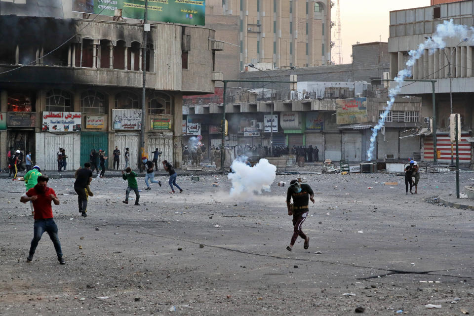 Riot police fire tear gas during clashes between Iraqi security forces and anti-government demonstrators, at Khilani Square in Baghdad, Iraq, Friday, Nov. 15, 2019. (AP Photo/Khalid Mohammed)