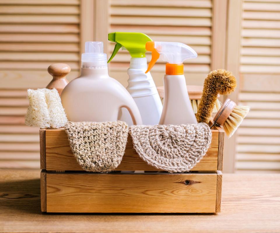 A wooden crate filled with non-branded cleaning spray bottles