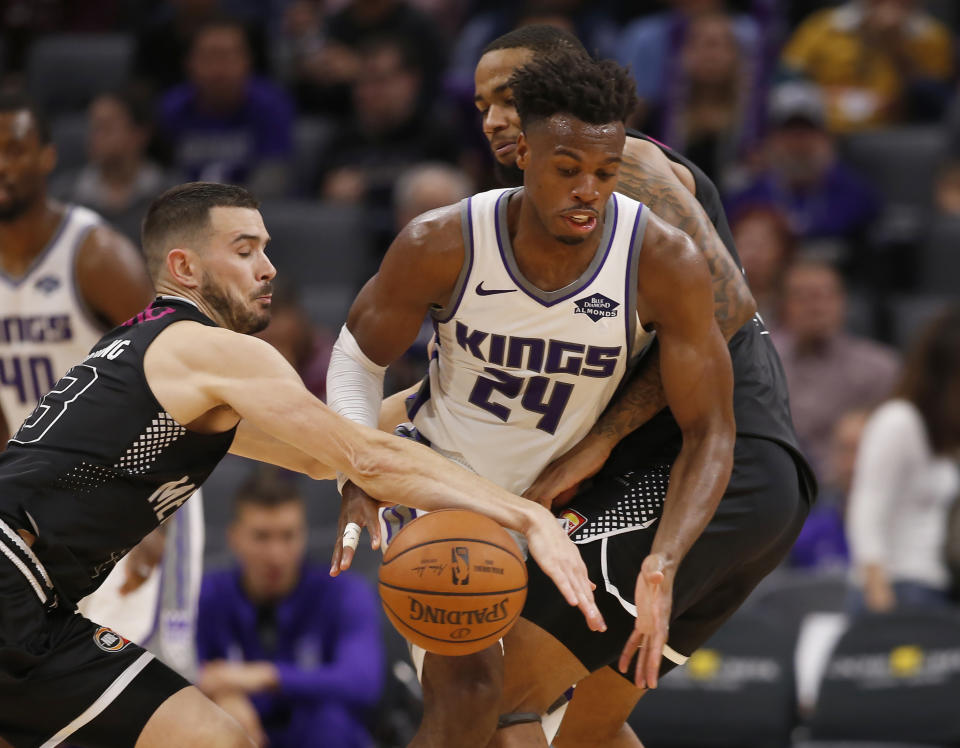 Sacramento Kings guard Buddy Hield, center, steals a pass intended for Melbourne United guard Chris Goulding, left, during the second half of an NBA exhibition basketball game in Sacramento, Calif., Wednesday, Oct. 16, 2019. The Kings won 124-110. (AP Photo/Rich Pedroncelli)