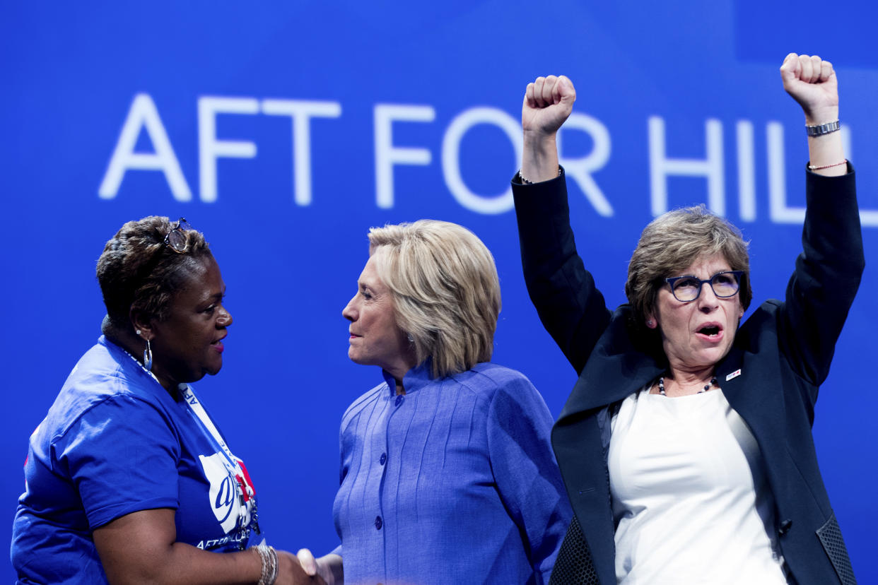 Democratic presidential candidate Hillary Clinton, center, greets a supporter on stage with AFT President Randi Weingarten, right, after speaking at the American Federation of Teachers convention at the Minneapolis Convention Center in Minneapolis, Monday, July 18, 2016. (AP Photo/Andrew Harnik)