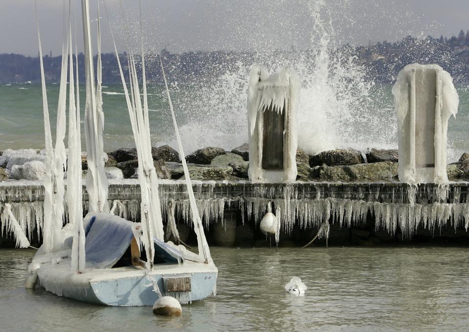 FILE - In this Monday, Feb. 28, 2005 file photo, a boat coated with ice lies at an embankment of lake Geneva, Switzerland. A cold north east wind came up on Monday and brought temperatures of down to minus 20 degrees centigrade (minus 4 Fahrenheit). On Friday, Feb. 19, 2021, The Associated Press reported on a photo circulating online incorrectly asserting it shows boats covered with ice in a marina in Galveston, Texas, during this week’s record freeze. The scene was actually from Lake Geneva from the 2015 storm in pictured in this similar photo. (Martial Trezzini/Keystone via AP)