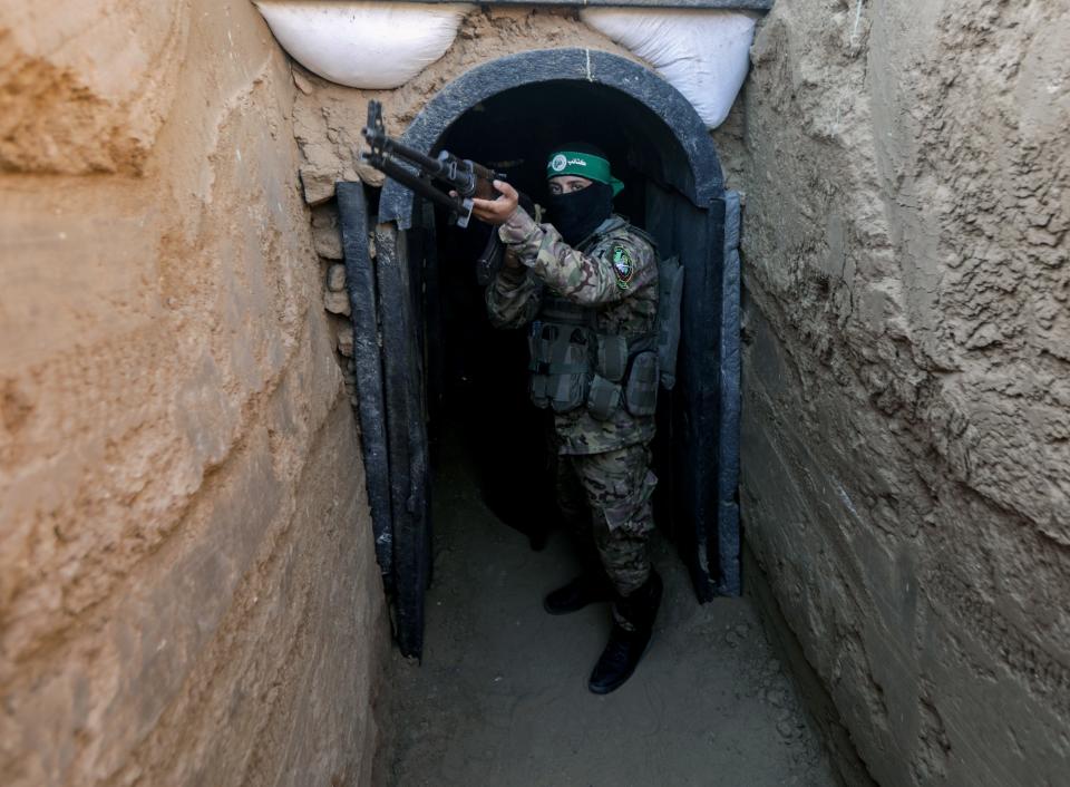 A fighter from Izz al-Din al-Qassam stands in front of a tunnel during an exhibition of weapons, missiles and heavy equipment for the military wing of Hamas.