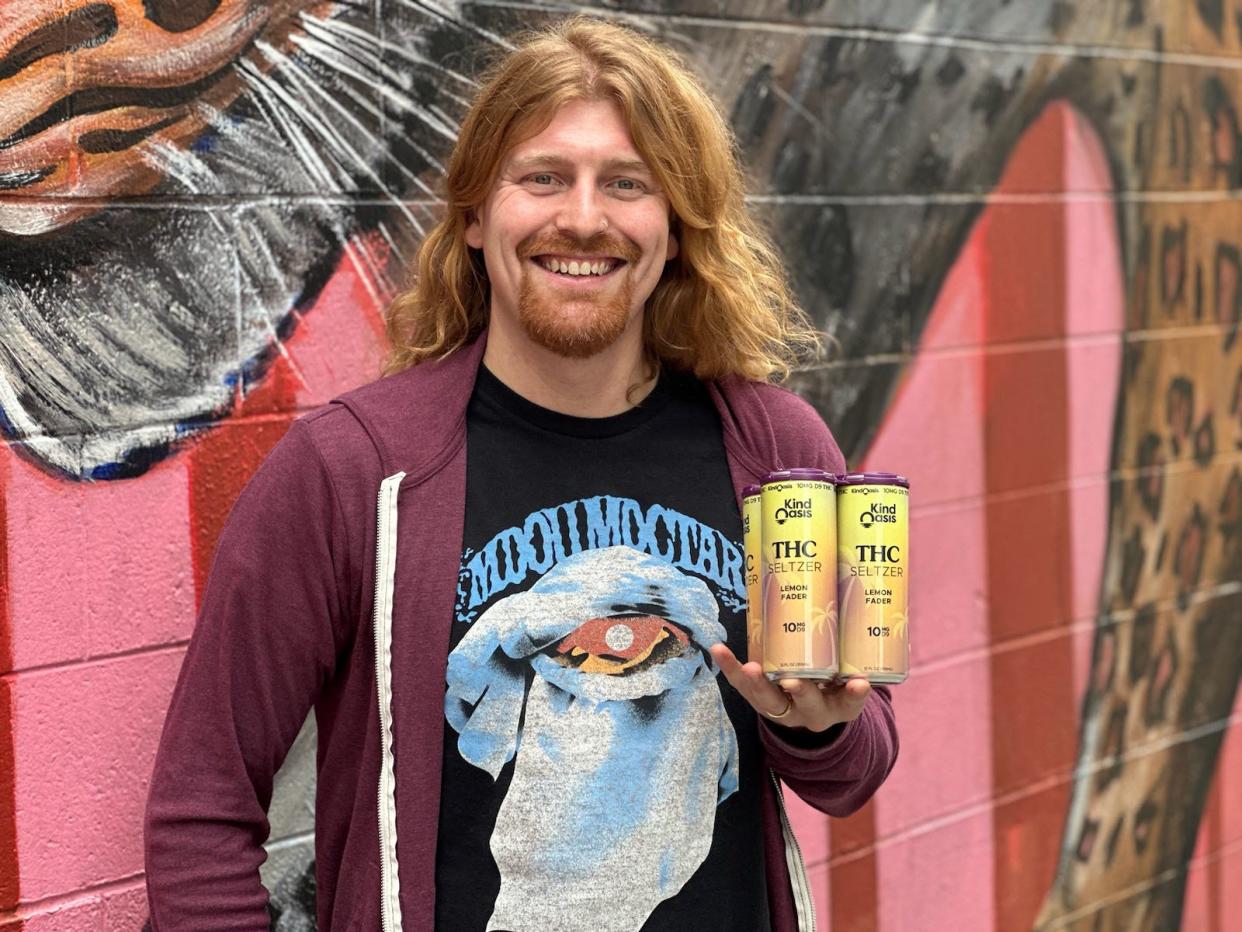 Grant Steskal, event and retail coordinator and Kind Oasis, poses with their THC seltzer outside oKind Oasis, 2169 N. Farwell Ave.