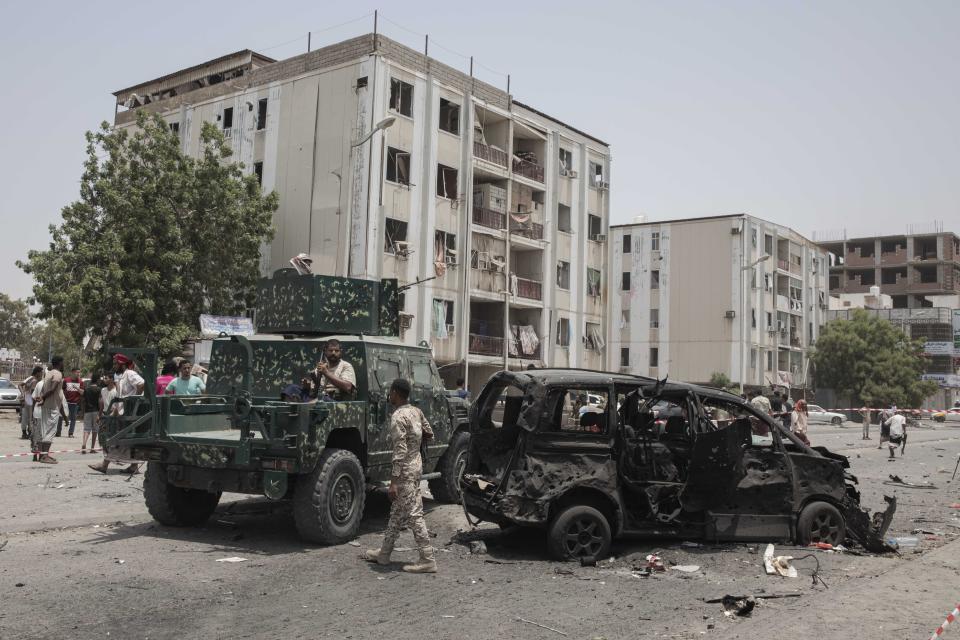 Civilians and security forces gather at the site of a deadly attack on the Sheikh Othman police station, in Aden, Yemen, Thursday, Aug. 1, 2019. Yemen's rebels fired a ballistic missile at a military parade Thursday in the southern port city of Aden as coordinated suicide bombings targeted the police station in another part of the city. The attacks killed over 50 people and wounded dozens. (AP Photo/Nariman El-Mofty)