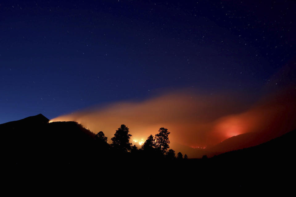 FILE- This July 21, 2019 photo shows pockets of wildfires within the Museum fire on the slopes of the San Francisco Peaks near Flagstaff, Ariz. Monsoon season carries high hopes for rain, thunder and lightning across the US Southwest, but it failed to deliver this year. Several communities in northern Arizona had the driest monsoon season on record, including Flagstaff. The season is characterized by a shift in wind patterns and moisture being pulled in from the tropical coast of Mexico. It runs from mid-June through September. (Jake Bacon/Arizona Daily Sun via AP)