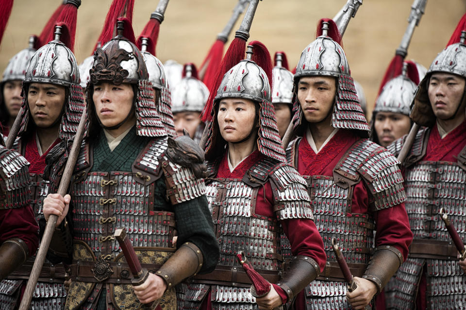 This image released by Disney shows Yifei Liu, center, in the title role of "Mulan." (Jasin Boland/Disney via AP)