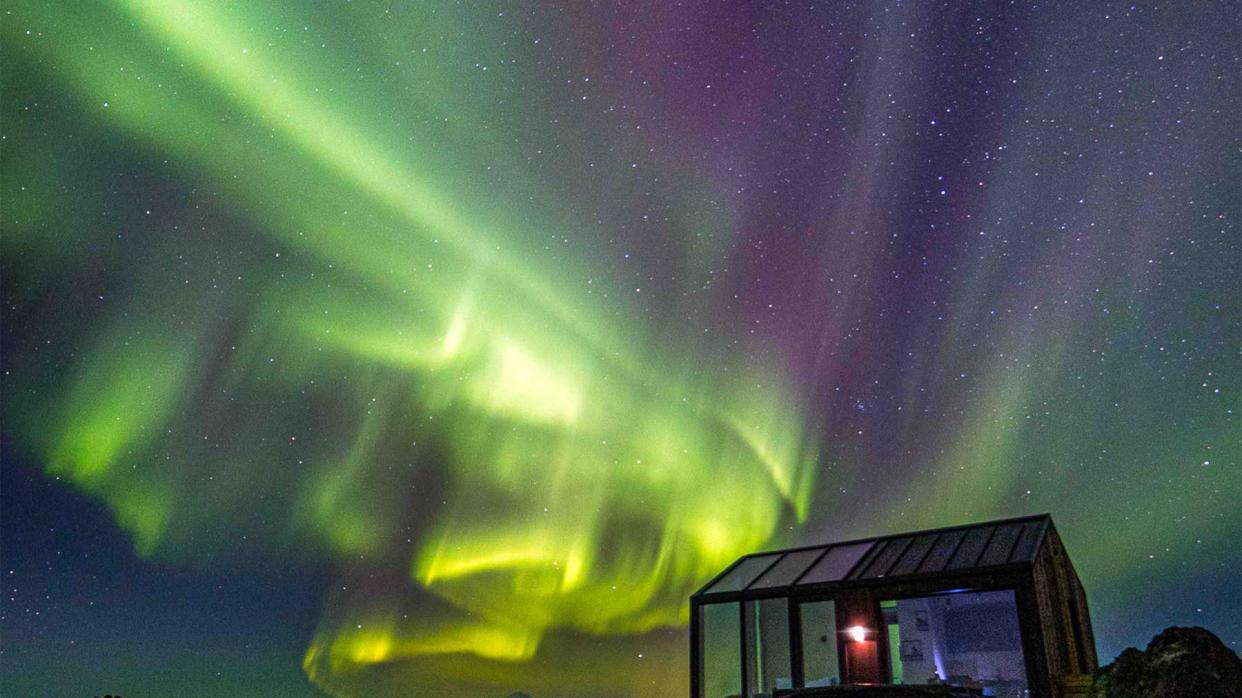 Glass house in Hella, Iceland, vast landscape views and nighttime view of Northern Lights