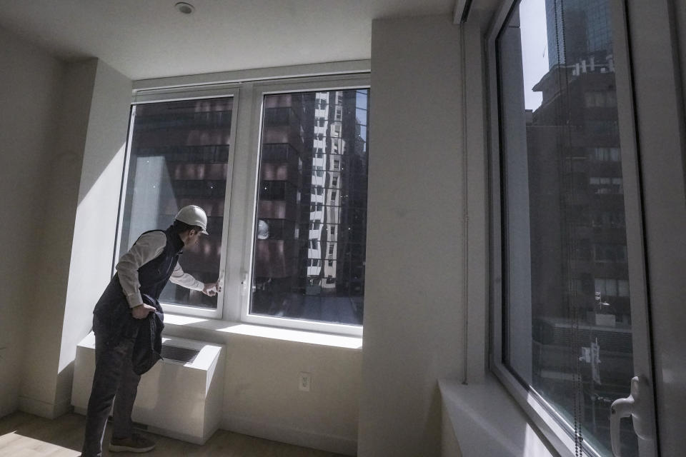 Joey Chilelli, managing director of real estate firm Vanbarton Group, demonstrates a window designed to protect birds from crashes, during a tour of a model apartment at a high rise undergoing conversion from commercial to residential apartments, Tuesday, April 11, 2023, in New York. (AP Photo/Bebeto Matthews)
