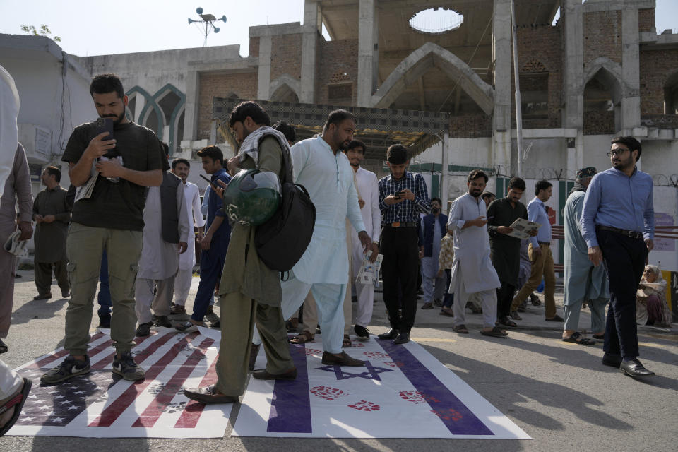 Shiite Muslims leave a mosque after Friday prayers as they walk over the representations of Israeli and the U.S. flags as a protest against Israeli airstrikes on Gaza and to show solidarity with Palestinian people, in Islamabad, Pakistan, Friday, Oct. 13, 2023. (AP Photo/Anjum Naveed)