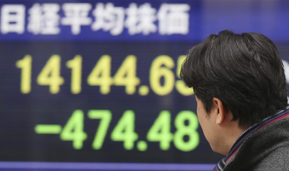 A man looks at an electronic stock board of a securities firm in Tokyo, Tuesday, Feb. 4, 2014. Weakness in U.S. and Chinese manufacturing sent Asian stock markets sharply lower Tuesday. (AP Photo/Koji Sasahara)