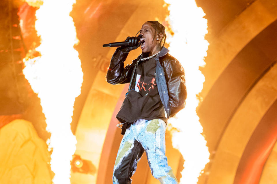 Travis performing onstage with pyrotechnics going off behind him