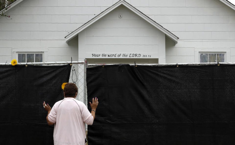 FILE - In this Nov. 12, 2017, file photo, a woman prays outside of the Sutherland Springs First Baptist Church in Sutherland Springs, Texas, a week after a man opened fire inside the church. Hundreds of people gathered in the tiny town for a Sunday service at a tent erected in a baseball field. The machete attack on a rabbi's home in Monsey, New York, during Hanukkah and the shooting of worshippers at a Texas church are refocusing attention on how vulnerable worshippers are during religious services. FBI hate crime statistics show there is reason for concern. (AP Photo/Eric Gay, File)