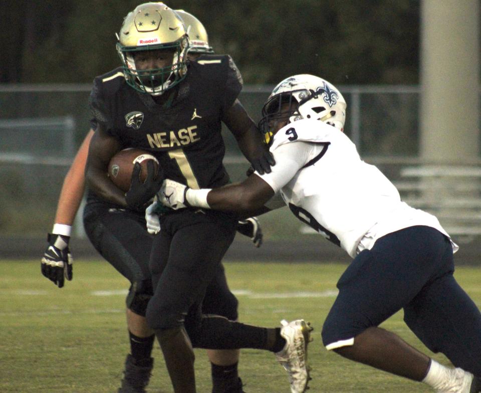 Nease wide receiver DaVon Patterson (1) tries to escape the tackle of Sandalwood's C.J. Allen (9) during a high school football game on October 4, 2022. [Clayton Freeman/Florida Times-Union]