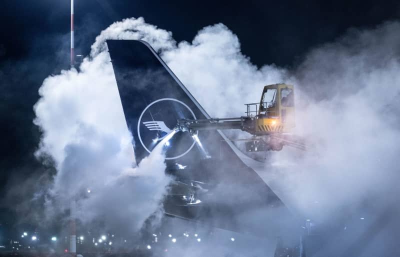 A Lufthansa aircraft is de-iced at Frankfurt Airport. Because of the weather conditions, the airport has scaled back its flight schedule. Boris Roessler/dpa