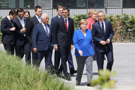 German Chancellor Angela Merkel, NATO Secretary General Jens Stoltenberg, Norway's Prime Minister Erna Solberg, Spain's Prime Minister Pedro Sanchez, Portugal's Prime Minister Antonio Costa, Greek Prime Minister Alexis Tsipras and Italy's Prime Minister Giuseppe Conte arrive for a family picture ahead of the opening ceremony of the NATO (North Atlantic Treaty Organization) summit, at the NATO headquarters in Brussels, Belgium, July 11, 2018. Ludovic Marin/Pool via REUTERS