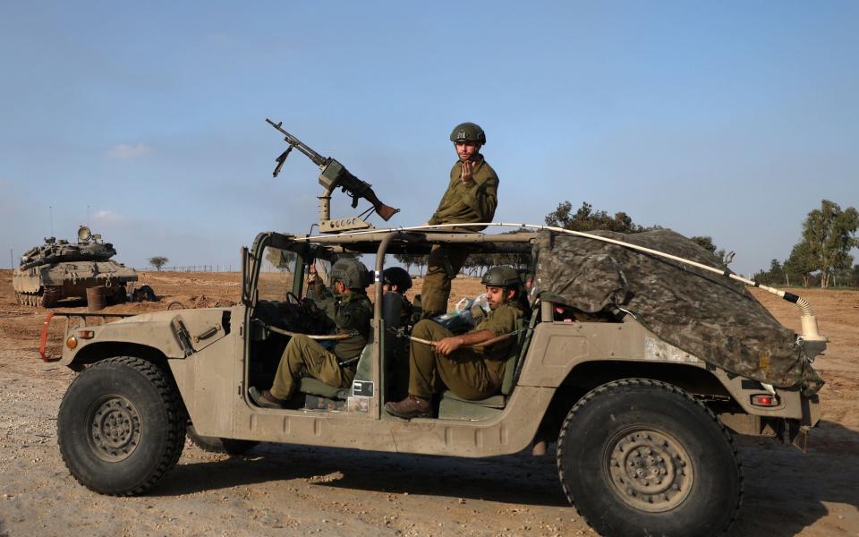 Israeli soldiers in an open-top Humvee prepare to enter Gaza