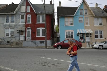 A man walks past multi-colored homes that face the now-closed Bethlehem Steel mill in Bethlehem, Pennsylvania, U.S. April 22, 2016. REUTERS/Brian Snyder