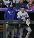 Injured Los Angeles Dodgers center fielder Cody Bellinger, left, looks on with first base coach Clayton McCullough in the ninth inning of a baseball game against the Colorado Rockies Tuesday, Sept. 21, 2021, in Denver. (AP Photo/David Zalubowski)