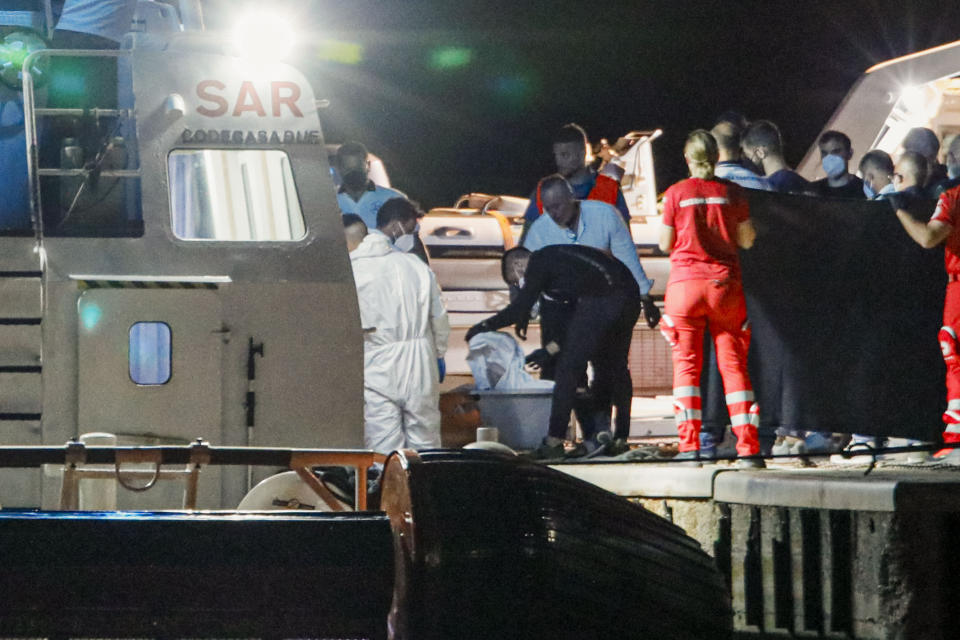 The bodies of some of the 64 migrants missing in the Mediterranean Sea after their ship wrecked off Italy's southern coast are disembarked at the Italian southern port-city of Roccella Ionica, early Wednesday, June 19, 2024. U.N. agencies said the boat that wrecked off Calabria had set off from Turkey eight days earlier and caught fire and overturned. Eleven people were rescued Monday, but one died soon after they were brought to land. (AP Photo/Valeria Ferraro)