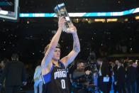 Osceola Magic's Mac McClung holds the trophy after winning the slam dunk competition at the NBA basketball All-Star weekend, Saturday, Feb. 17, 2024, in Indianapolis. (AP Photo/Darron Cummings)