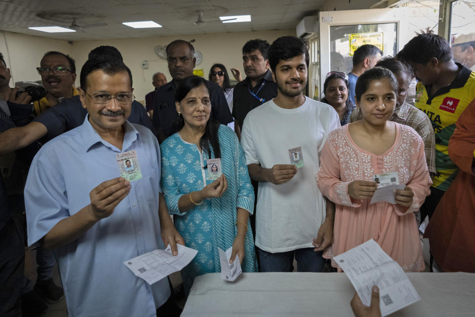 Aam Aadmi Party leader and Chief Minister of Delhi, Arvind Kejriwal, left, stands next to his family members as they show their identity cards at a polling booth before casting their vote in the sixth round of polling in India's national election in New Delhi, India, Saturday, May 25, 2024. (AP Photo/Altaf Qadri)