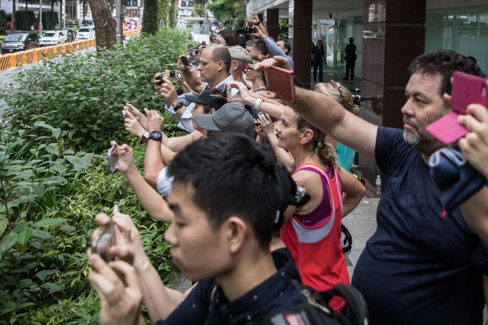 More people take photos outside the St. Regis hotel.