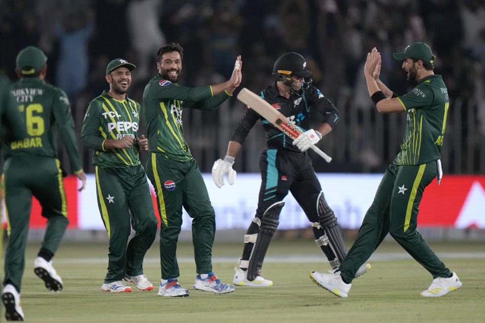 Pakistan's Mohammad Amir, third left, celebrates with teammates after taking the wicket of New Zealand's Tim Robinson, second right, during the second T20 international cricket match between Pakistan and New Zealand, in Rawalpindi, Pakistan, Saturday, April 20, 2024. (AP Photo/Anjum Naveed)