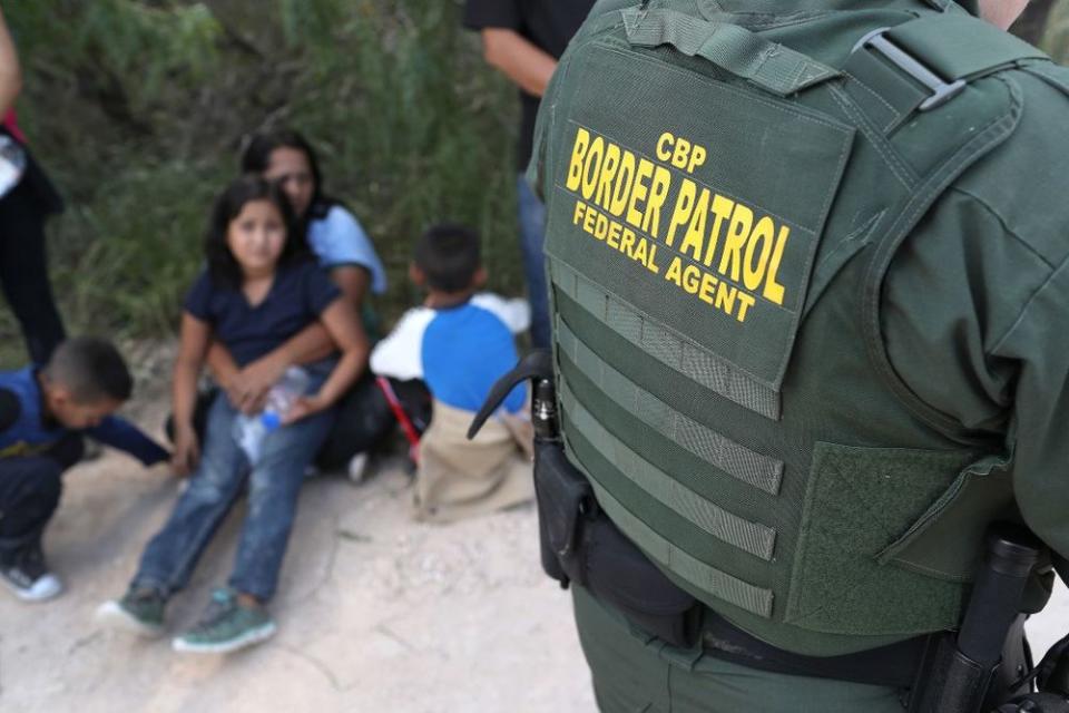 Central American asylum seekers wait as U.S. Border Patrol agents take them into custody on June 12, 2018 near McAllen, Texas